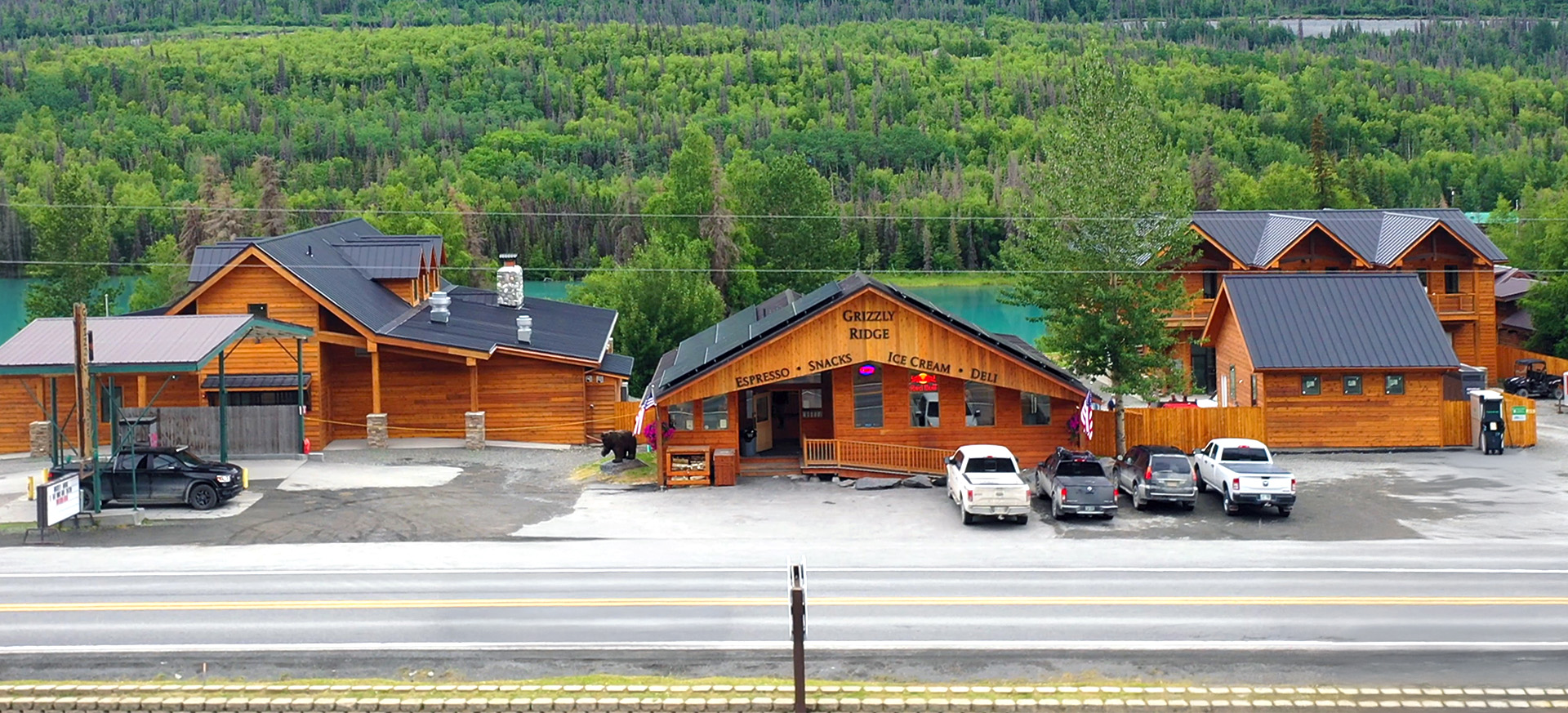 Grizzly Ridge convenience store and lodging in Cooper Landing, Alaska, featuring a rustic log cabin design with scenic river and forest views.